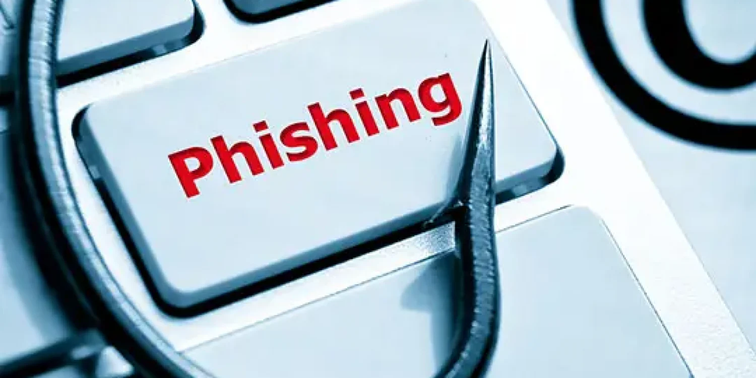 phishing / fish hook on computer keyboard with email sign